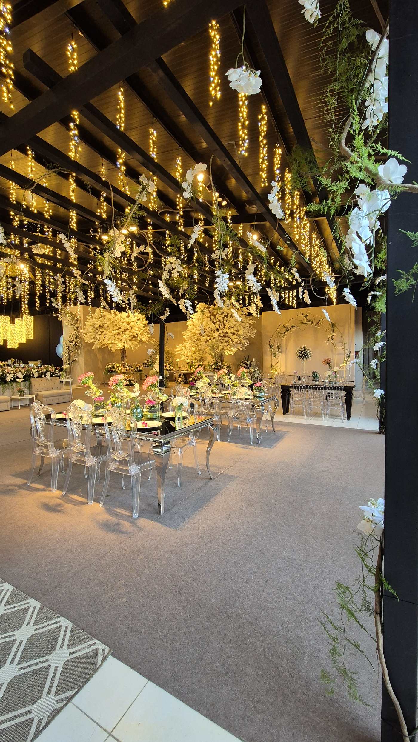 Salão amplo do Cerimonial da Barra decorado, com árvore floral e luzes